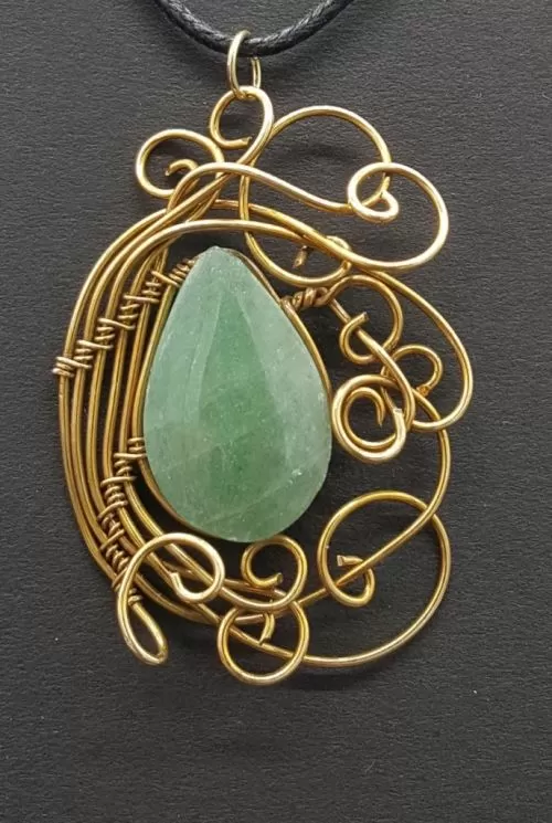 Dije de tumbaga con aventurina de color verde. 