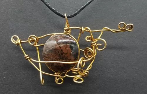 Dije de piedra jaspe marrón con tumbaga. 